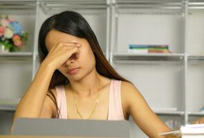 Asian woman working from home Tired of paperwork that is not completed on time photo