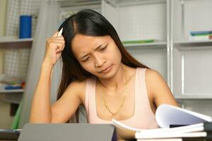 Asian woman working from home Tired of paperwork that is not completed on time photo