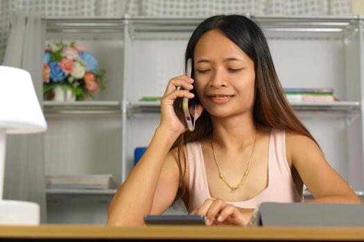 woman working at home Use your phone and computer to communicate with your teammates. photo