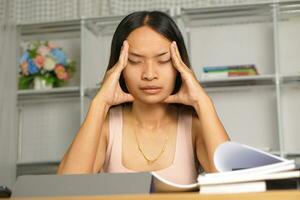 Asian woman working from home Tired of paperwork that is not completed on time photo