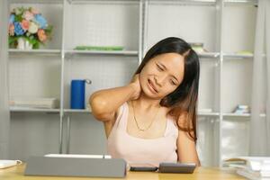 woman using phone at home desk Pain from sitting for a long time photo