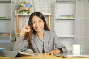 Happy businesswoman raising her hands in joy as she reached a business deal with a customer. photo