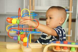 Boy playing with developmental toys on table at home photo