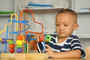 Boy playing with developmental toys on table at home photo