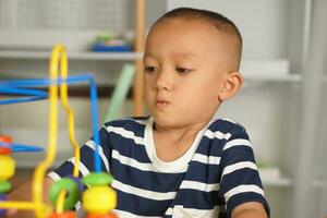 Boy playing with developmental toys on table at home photo