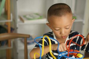 Boy playing with developmental toys on table at home photo