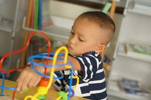 Boy playing with developmental toys on table at home photo