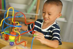 Boy playing with developmental toys on table at home photo