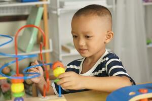 Boy playing with developmental toys on table at home photo