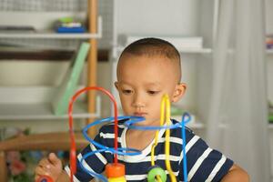 Boy playing with developmental toys on table at home photo