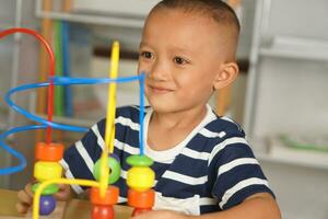 Boy playing with developmental toys on table at home photo