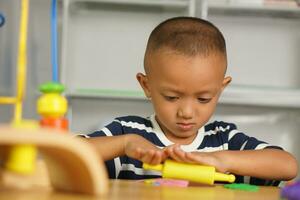 A boy kneads plasticine to make things soft. photo