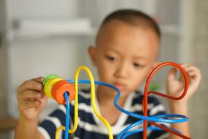 Boy playing with developmental toys on table at home photo