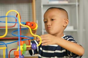 Boy playing with developmental toys on table at home photo