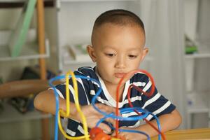 Boy playing with developmental toys on table at home photo