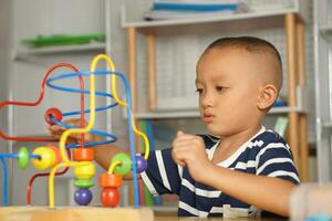 Boy playing with developmental toys on table at home photo