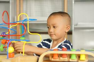 Boy playing with developmental toys on table at home photo