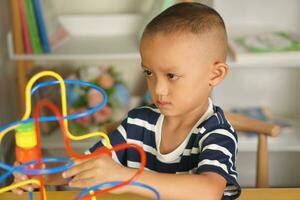 Boy playing with developmental toys on table at home photo