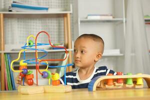 Boy playing with developmental toys on table at home photo