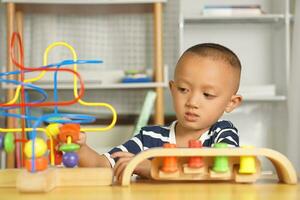 Boy playing with developmental toys on table at home photo