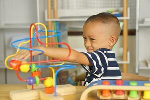 Boy playing with developmental toys on table at home photo