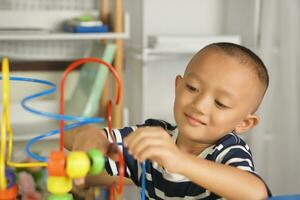 Boy playing with developmental toys on table at home photo