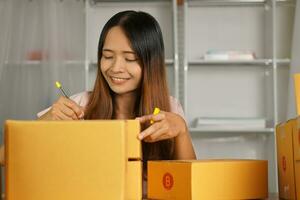 Online retailer checking customer's address on box before sending the goods photo