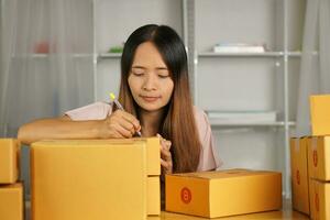 Online retailer checking customer's address on box before sending the goods photo