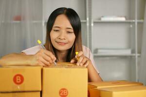 Online retailer checking customer's address on box before sending the goods photo