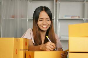 Online retailer checking customer's address on box before sending the goods photo