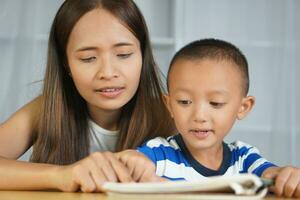 Mother teaching son to do homework photo