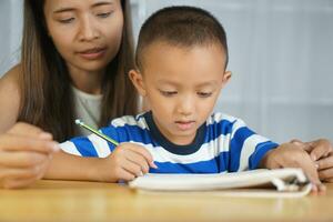 Mother teaching son to do homework photo