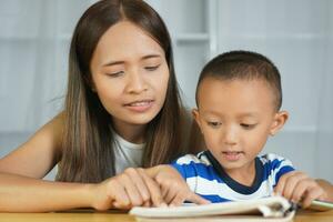 Mother teaching son to do homework photo