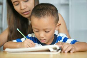 Mother teaching son to do homework photo