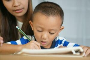 Mother teaching son to do homework photo