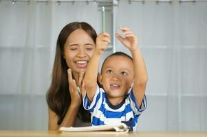 Mother teaching son to do homework photo