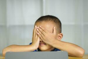 Boy has eye strain from looking at computer for a long time photo