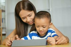 contento madre y hijo desde acecho películas juntos en un portátil computadora foto