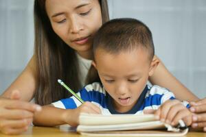 Mother teaching son to do homework photo