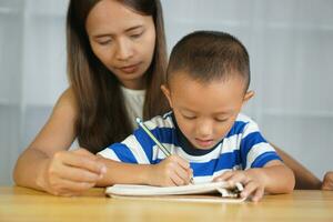 Mother teaching son to do homework photo