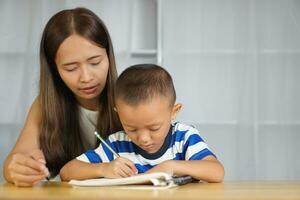 Mother teaching son to do homework photo