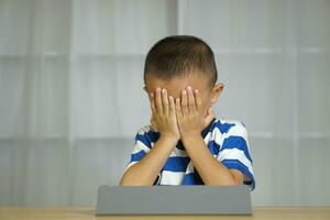 Boy has eye strain from looking at computer for a long time photo