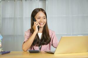 Online seller talking on the phone with customers happily from closing product deals photo