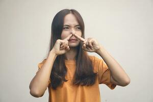 Asian woman covering her nose with her hands due to a bad smell photo