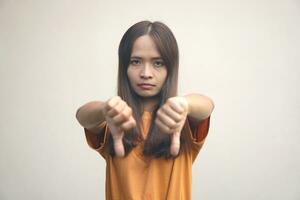 A woman holds her thumb upside down as a sign of the worst. photo