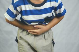 A boy has a stomach ache from not eating at the right time. photo