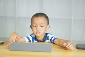 Boy sitting happily studying online photo