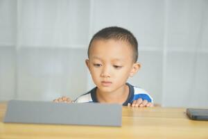 Boy sitting happily studying online photo