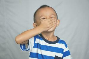 A boy covers his nose with his hand to prevent the bad smell. photo