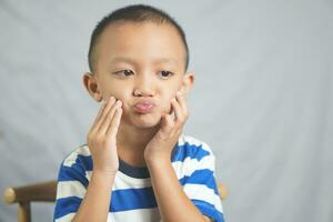 A boy has a toothache from gingivitis photo